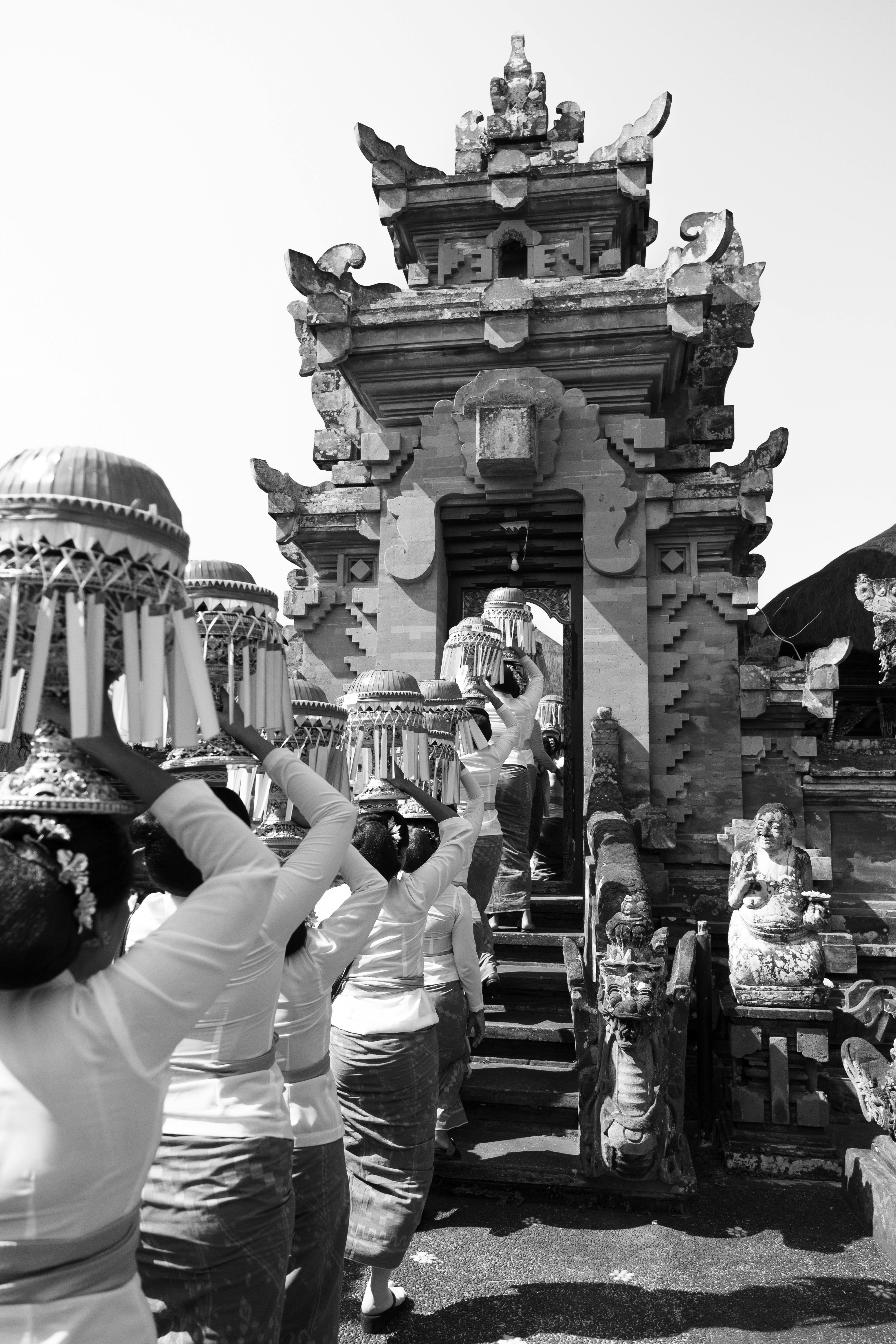 ฟรี สตรีในชุดดั้งเดิมเข้าร่วมพิธีกรรมแบบบาหลีที่วัดโบราณ คลังภาพถ่าย