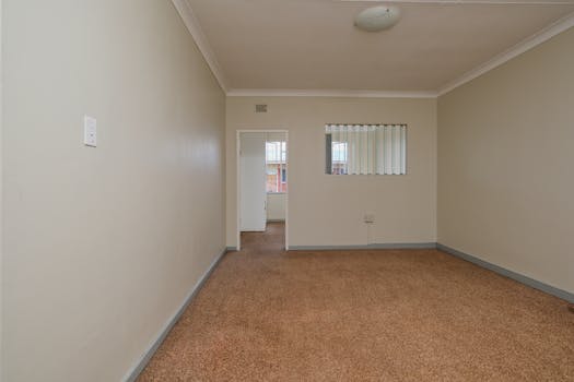 Spacious empty room featuring carpet flooring and neutral walls. Ideal for real estate listings.