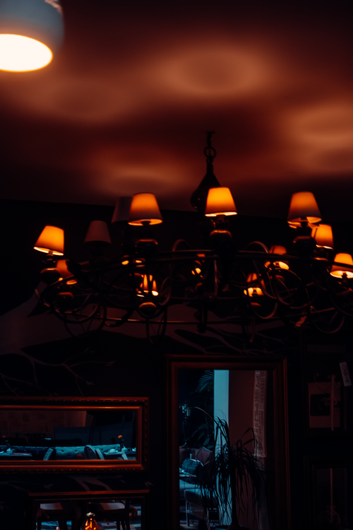 Free A warm and moody indoor scene featuring an elegant chandelier casting light in a Moroccan room. Stock Photo