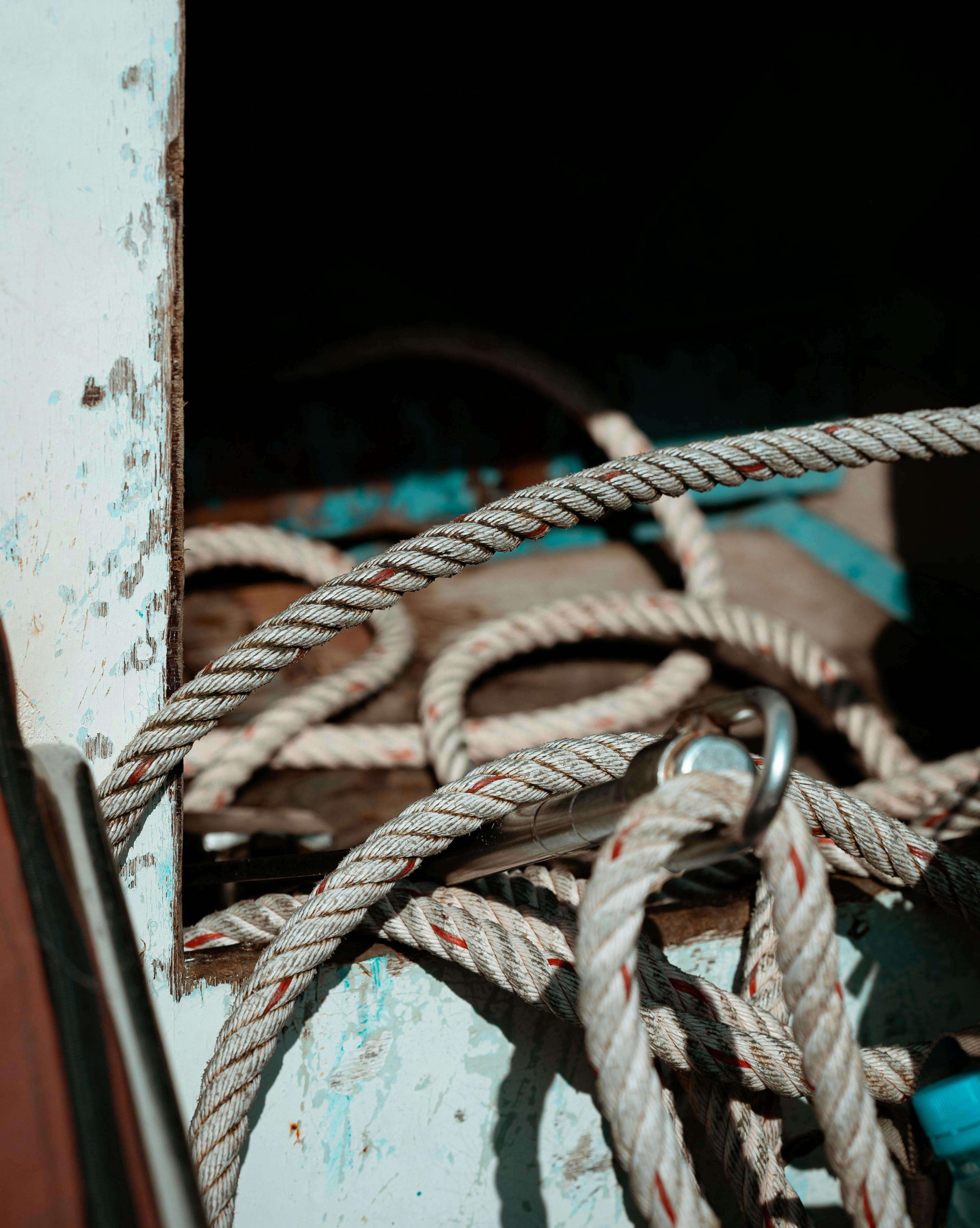 Gratis Vista dettagliata di una corda arrotolata sul ponte di una vecchia barca, che ne evidenzia la consistenza e l'usura. Foto a disposizione