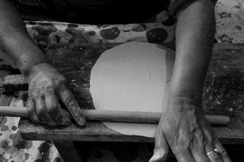Free Hands of an artisan rolling dough on a wooden board in black and white. Stock Photo