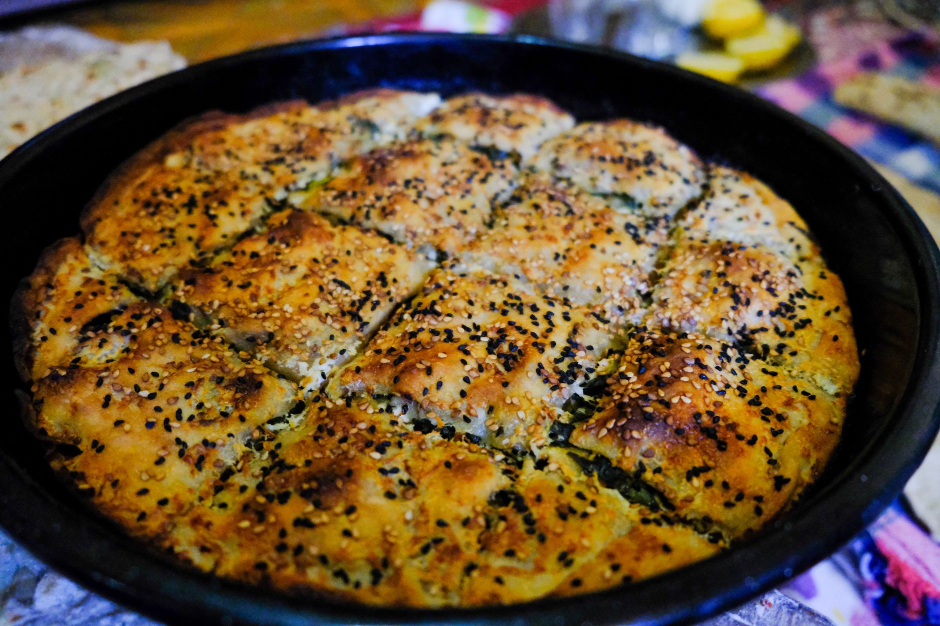 Sliced Turkish Borek with golden crust on wooden board