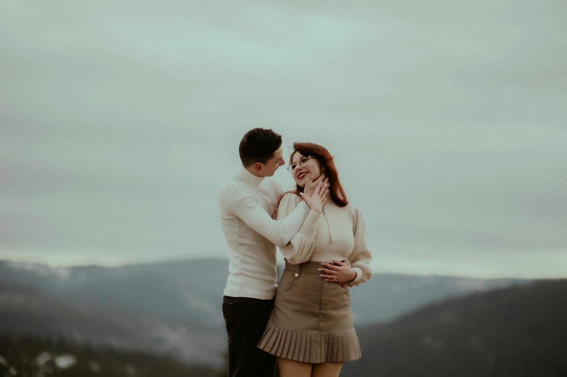 A loving couple embracing amidst the scenic autumn mountains of Beliș, Romania.