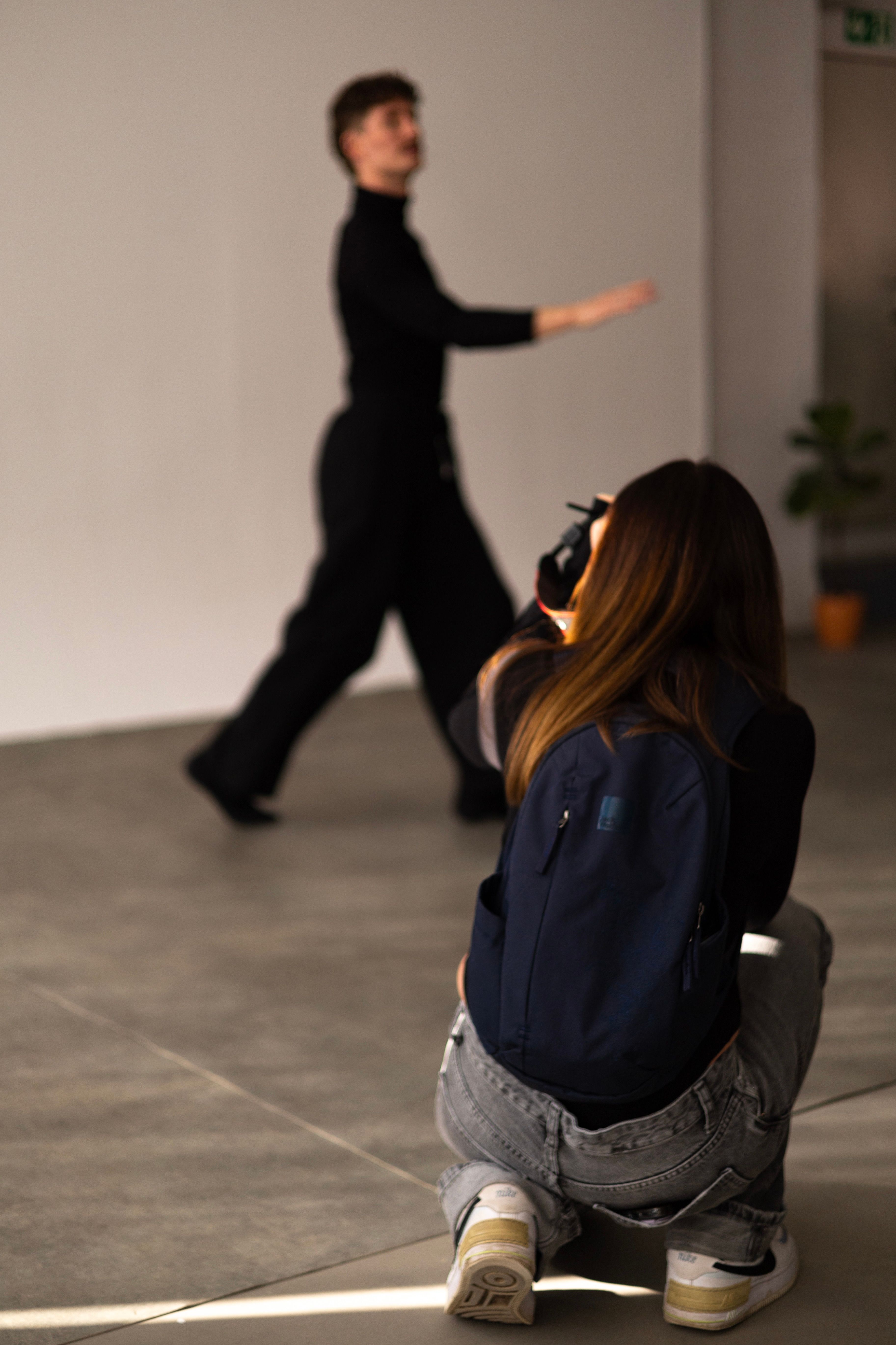 Photographer capturing a model in motion indoors, focusing on creative expression.