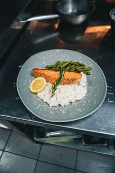 Grilled salmon paired with creamy rice and fresh green beans for a gourmet meal.