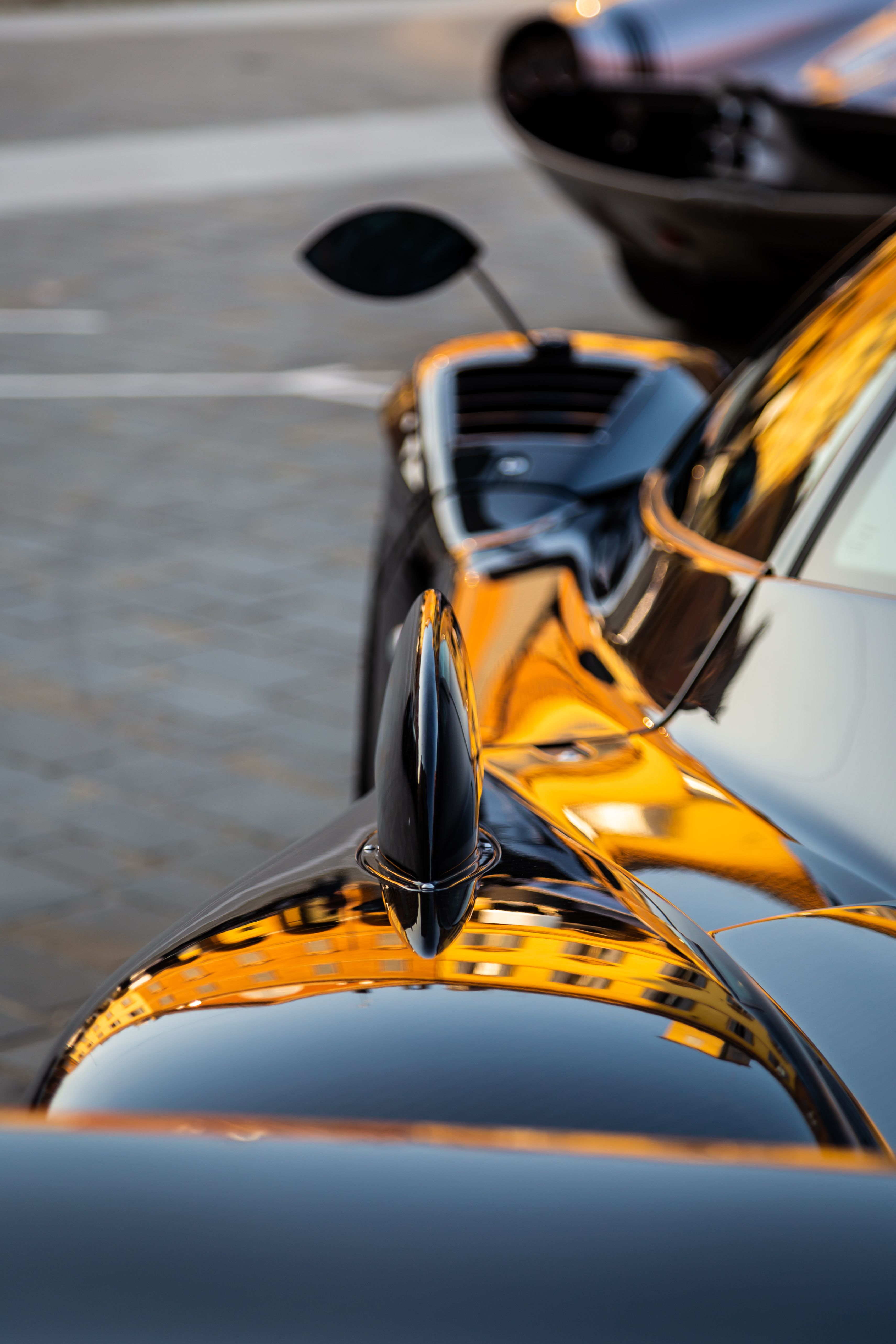 Close-up reflection on the polished black paint of a luxury sports car