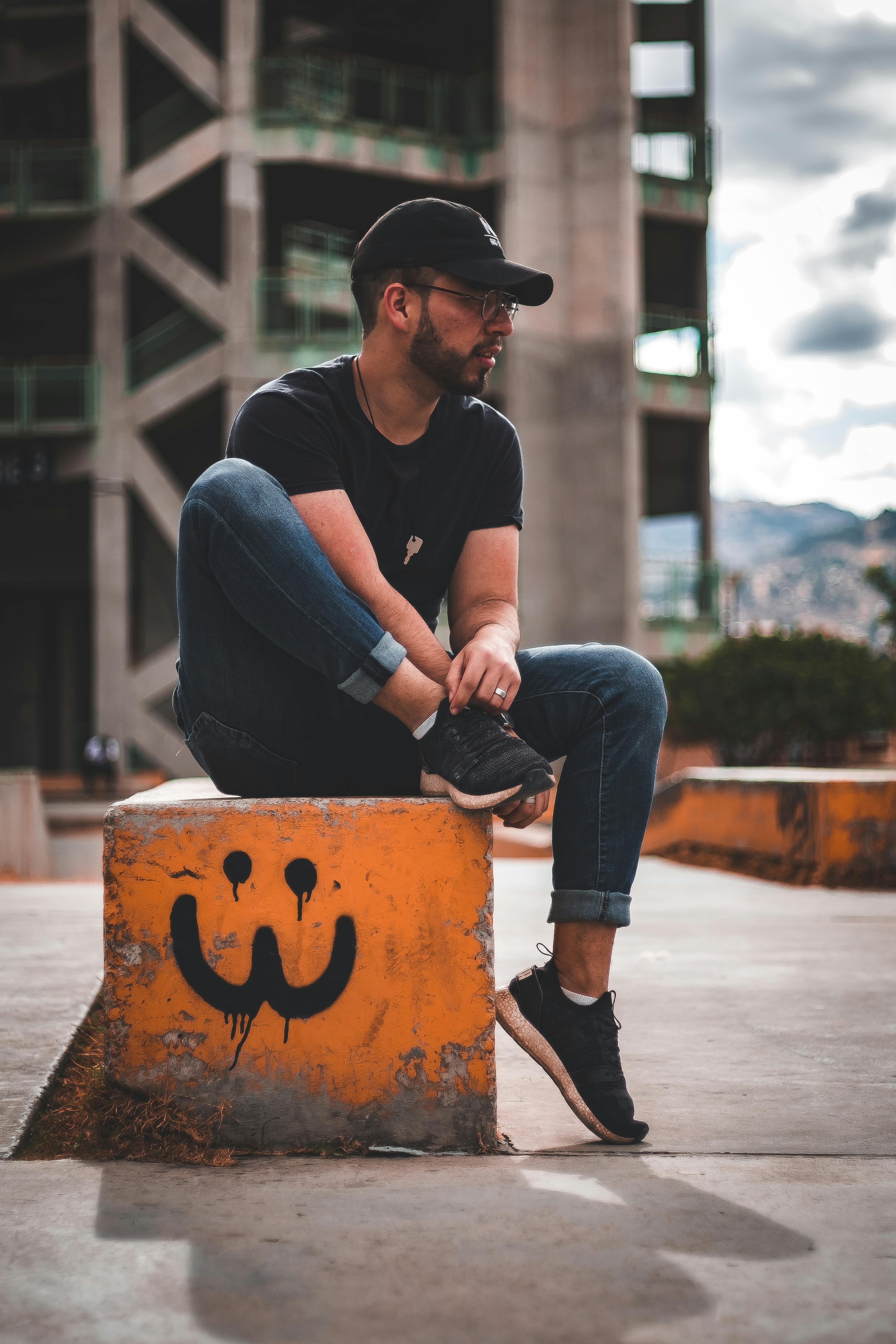 男子心情轻松地坐在涂鸦覆盖的城市街区上