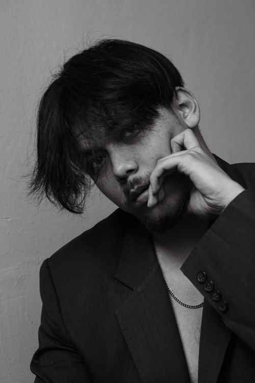Free Moody black and white portrait of a man deep in thought, dressed in a dark suit. Stock Photo