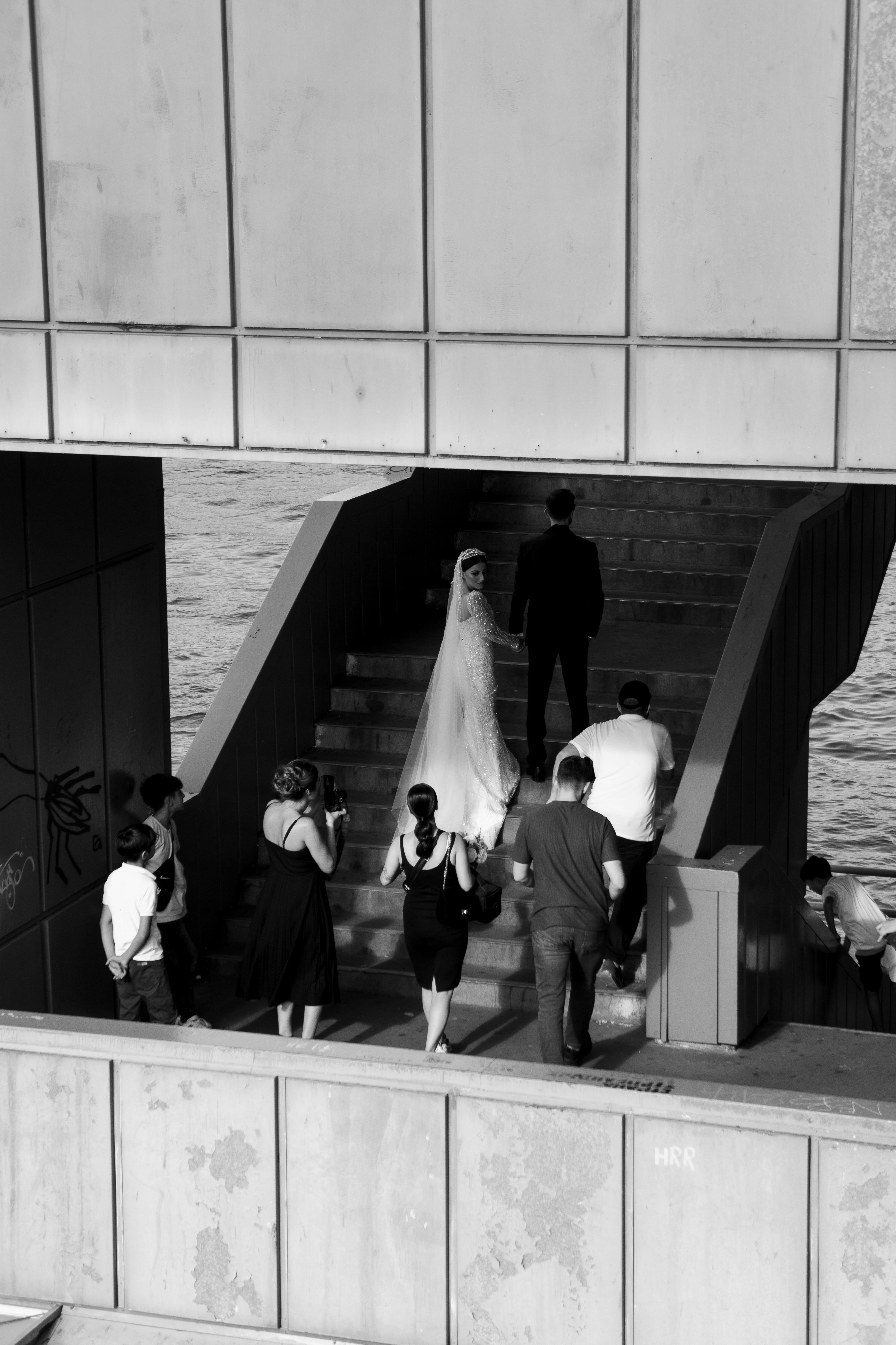 Black and white urban wedding photoshoot on a staircase by water.