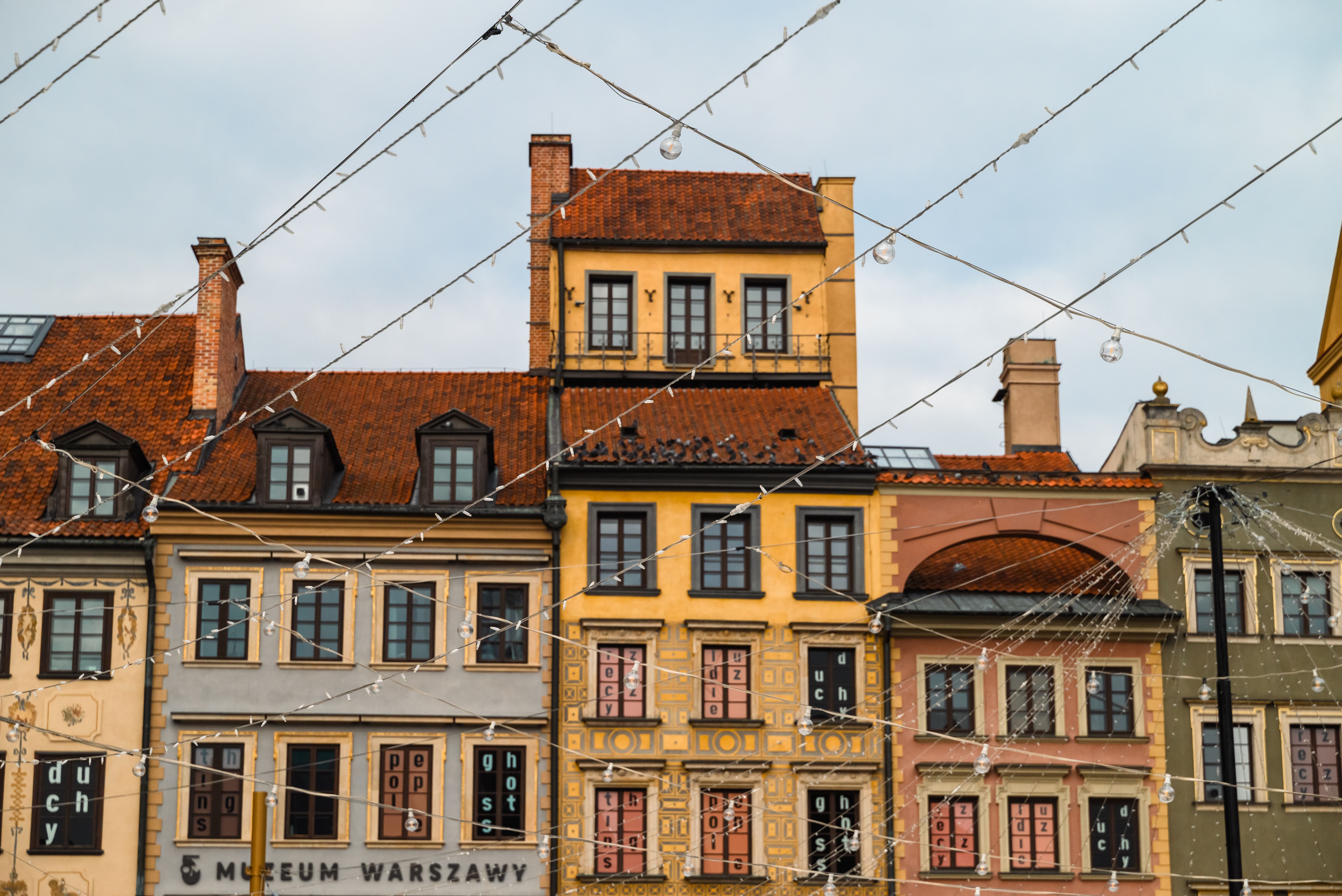 Group on a free walking tour exploring the colorful buildings of Warsaw Old Town, Poland