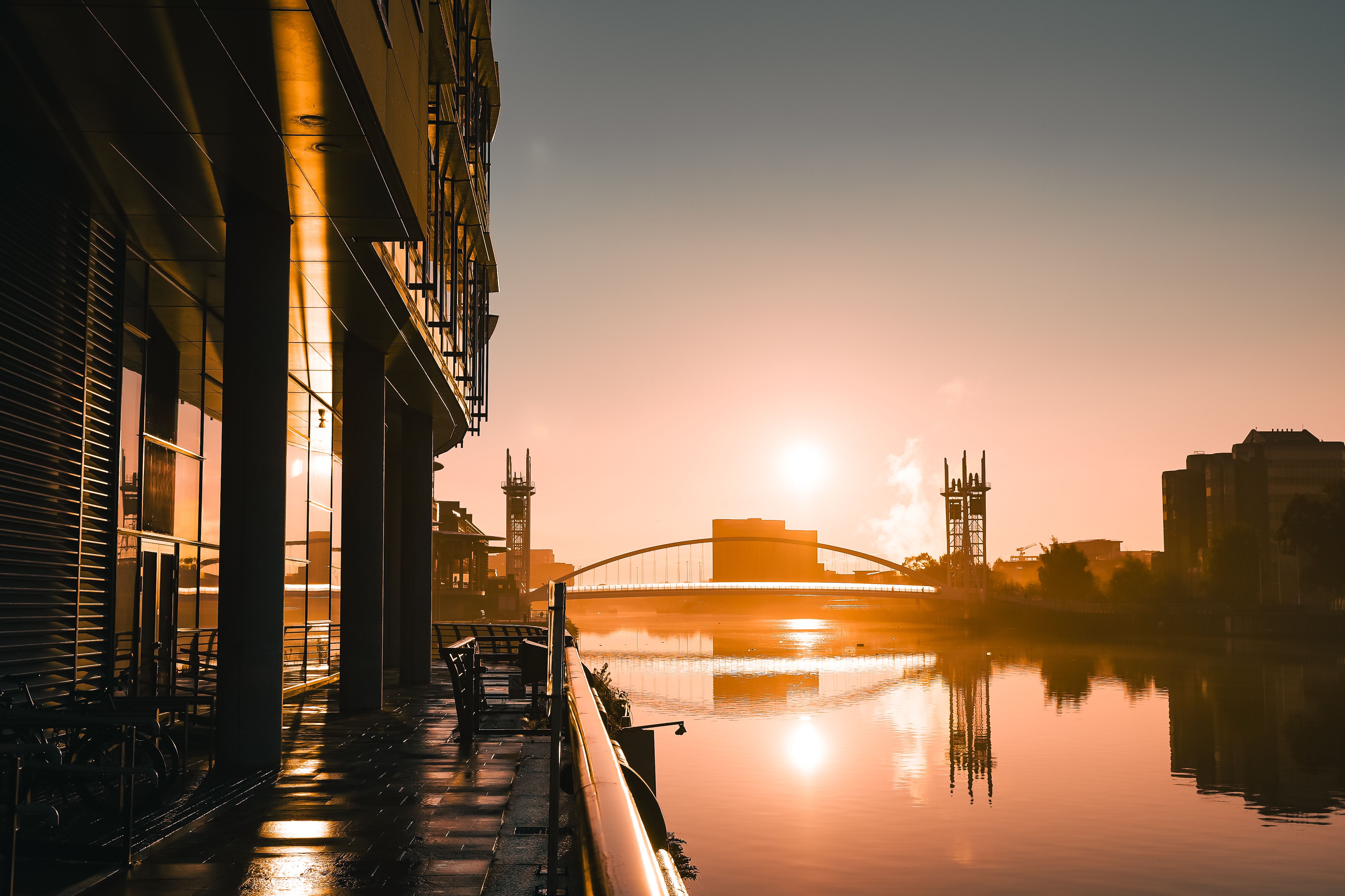 Stunning sunrise reflecting over Salford Quays, capturing modern urban architecture in warm tones.