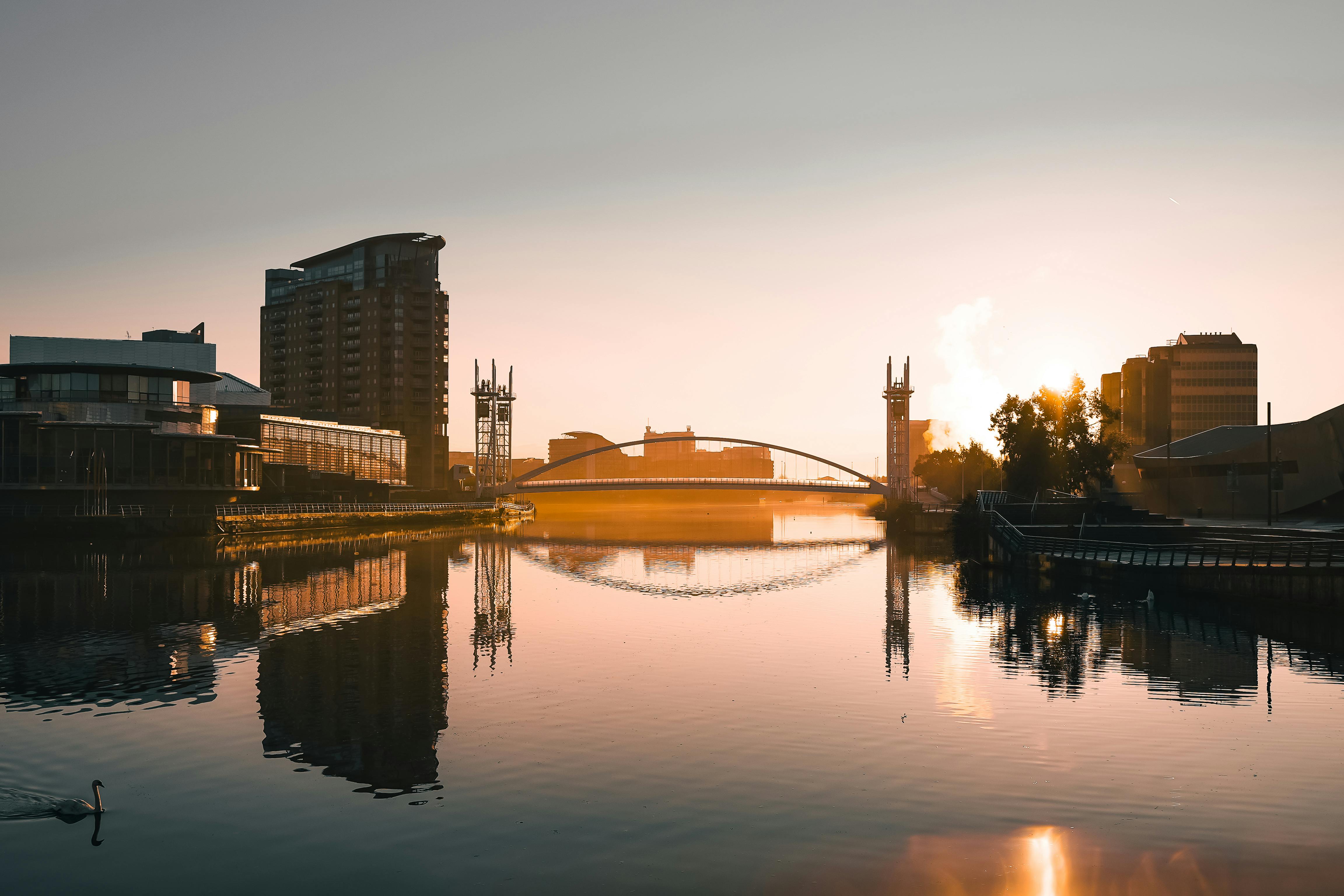 Stunning sunset at Salford Quays with city skyline reflections on calm water.