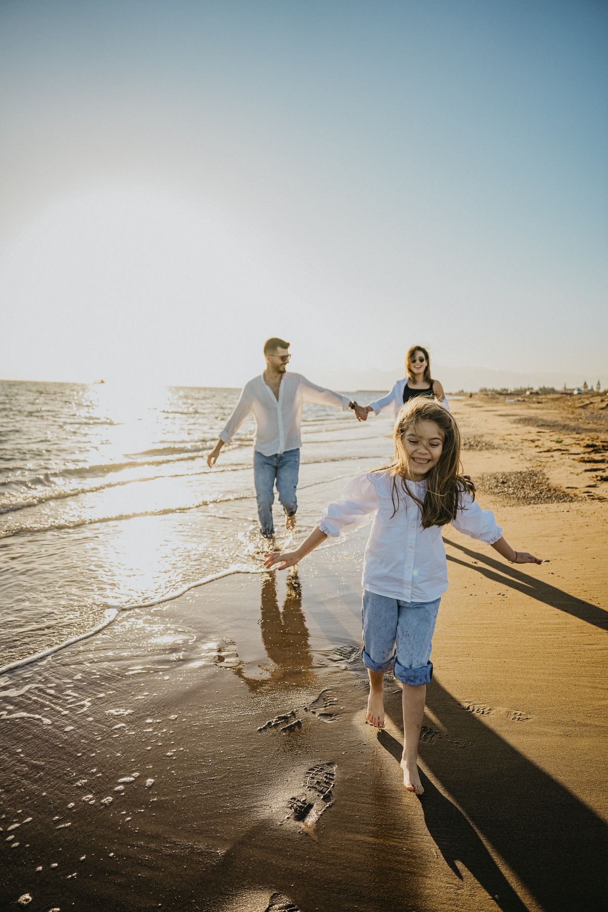 Family walking on a beach at sunset; illustrative image, not a verified Andaman location