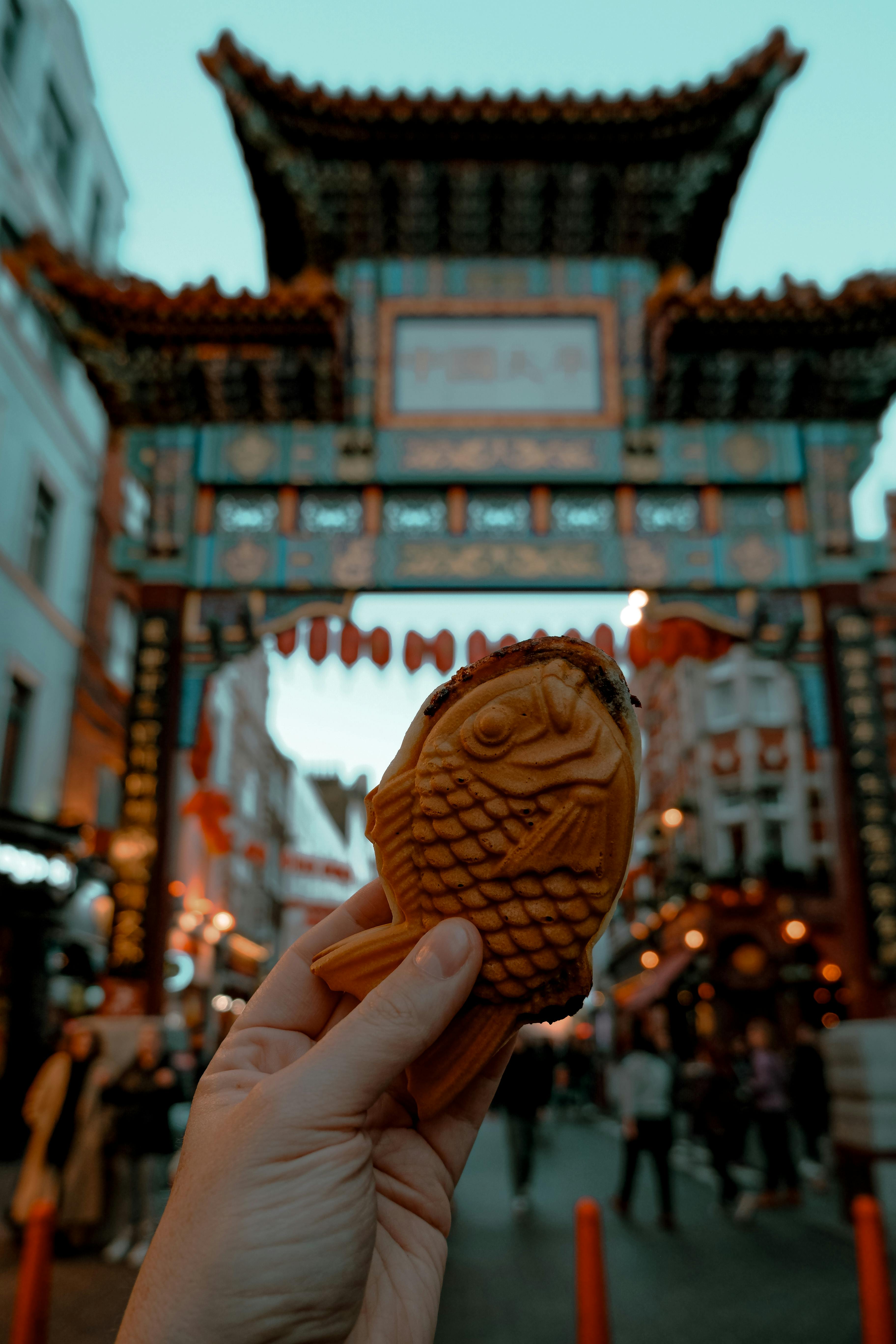 hand holding taiyaki in london s chinatown at twilight