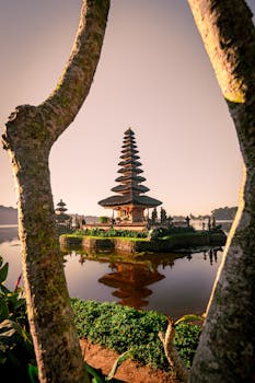 日出时，巴厘岛乌伦达努贝拉坦寺的风景倒映在平静的水中