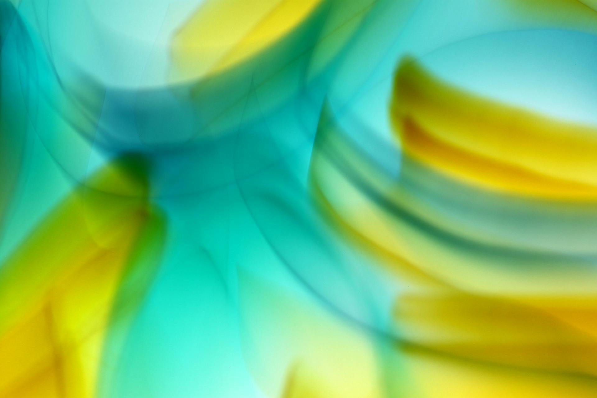 Vibrant abstract background featuring blurred waves of yellow and blue tones.