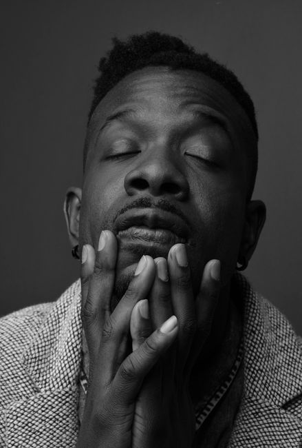 Black and white portrait of a stylish young man with a contemplative expression.