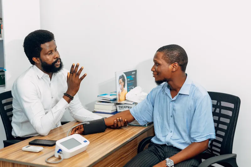A clinician taking a patient's blood pressure during a consultation