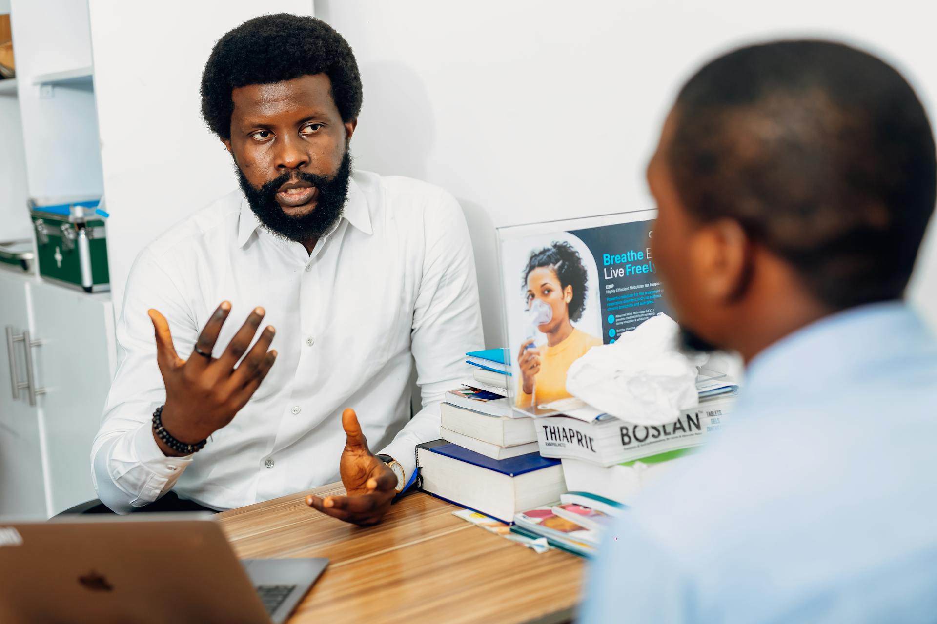 A doctor discusses health concerns with a patient at a medical office in Lagos, Nigeria.