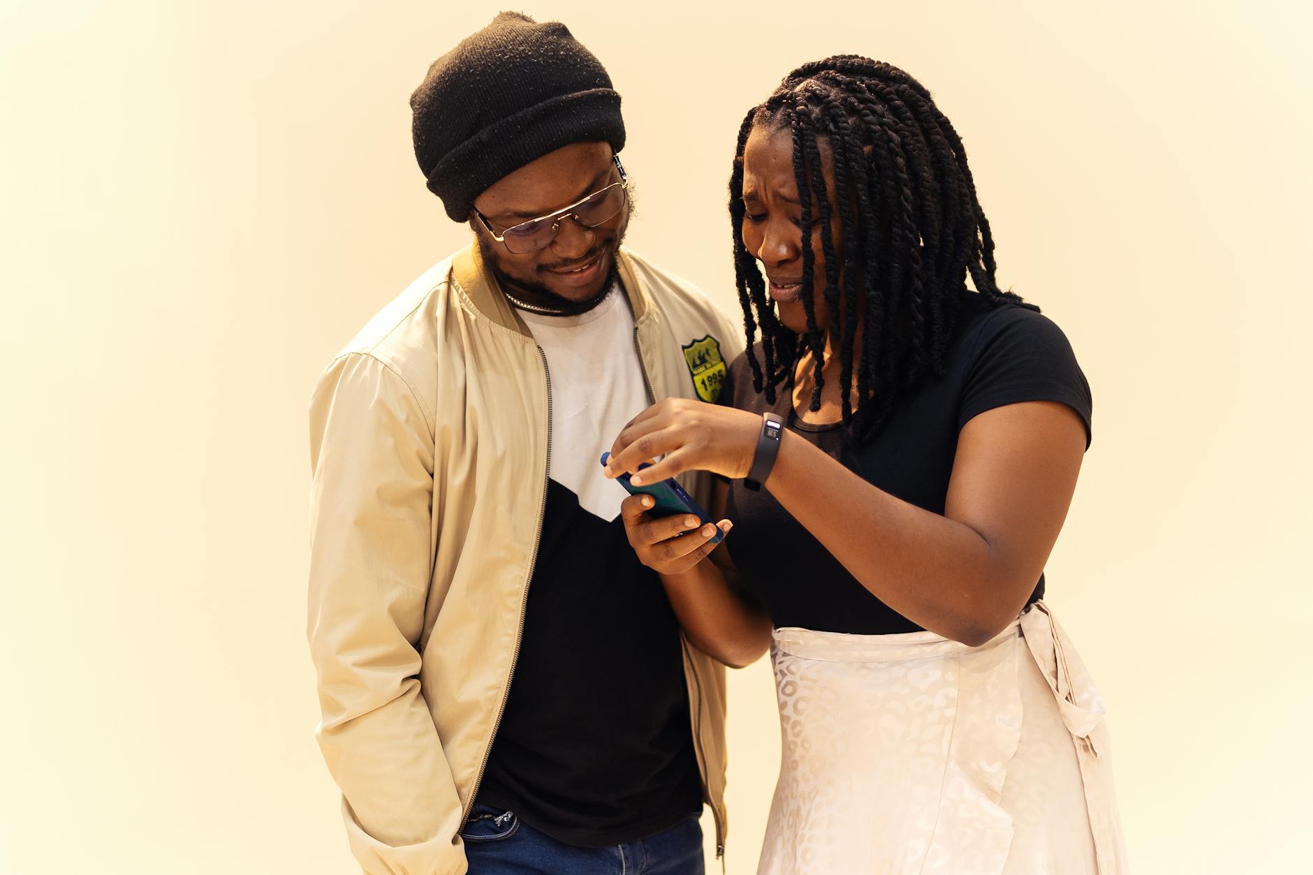 Two friends sharing a moment while looking at a phone in Lagos, Nigeria, captured with vibrant warmth.