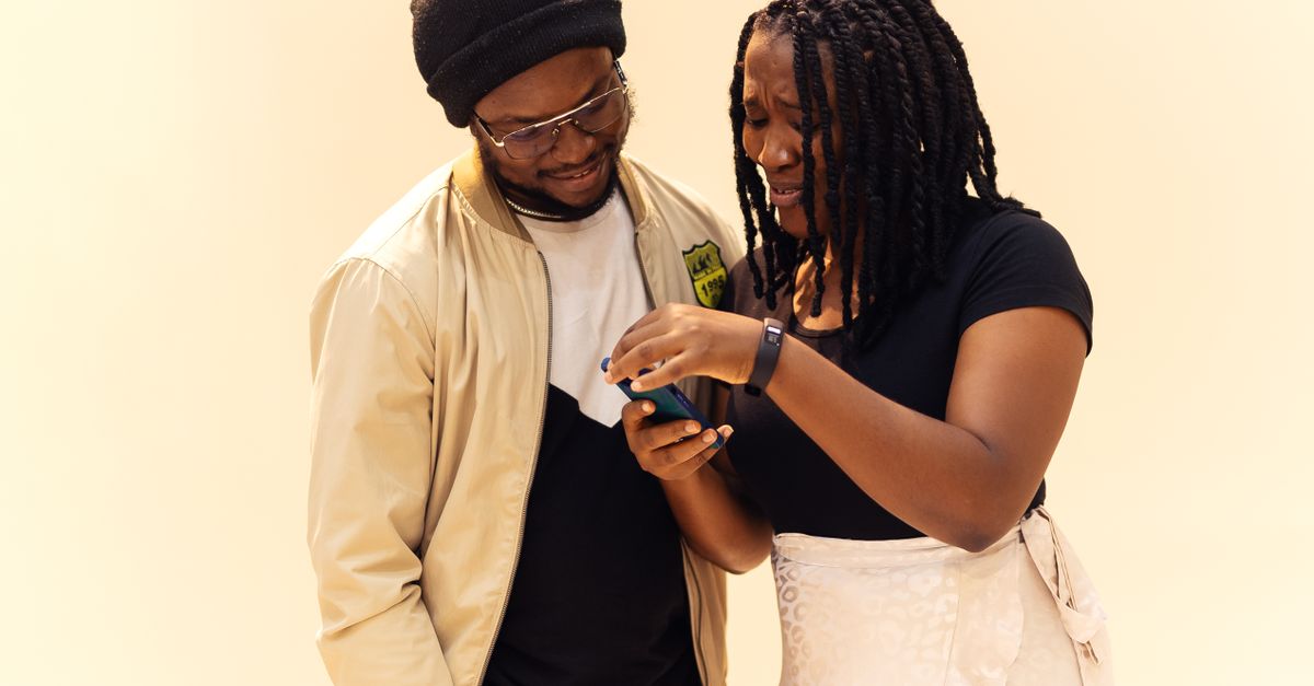 Two friends in Lagos checking earnings on a phone
