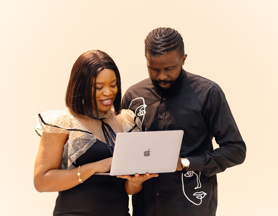 Two colleagues working together on a laptop in an office