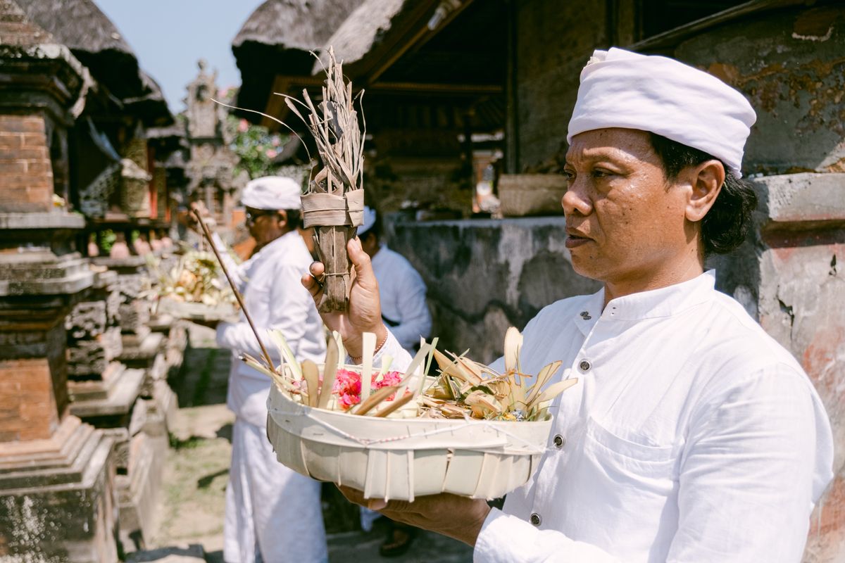 A Balinese priest carrying traditional offerings