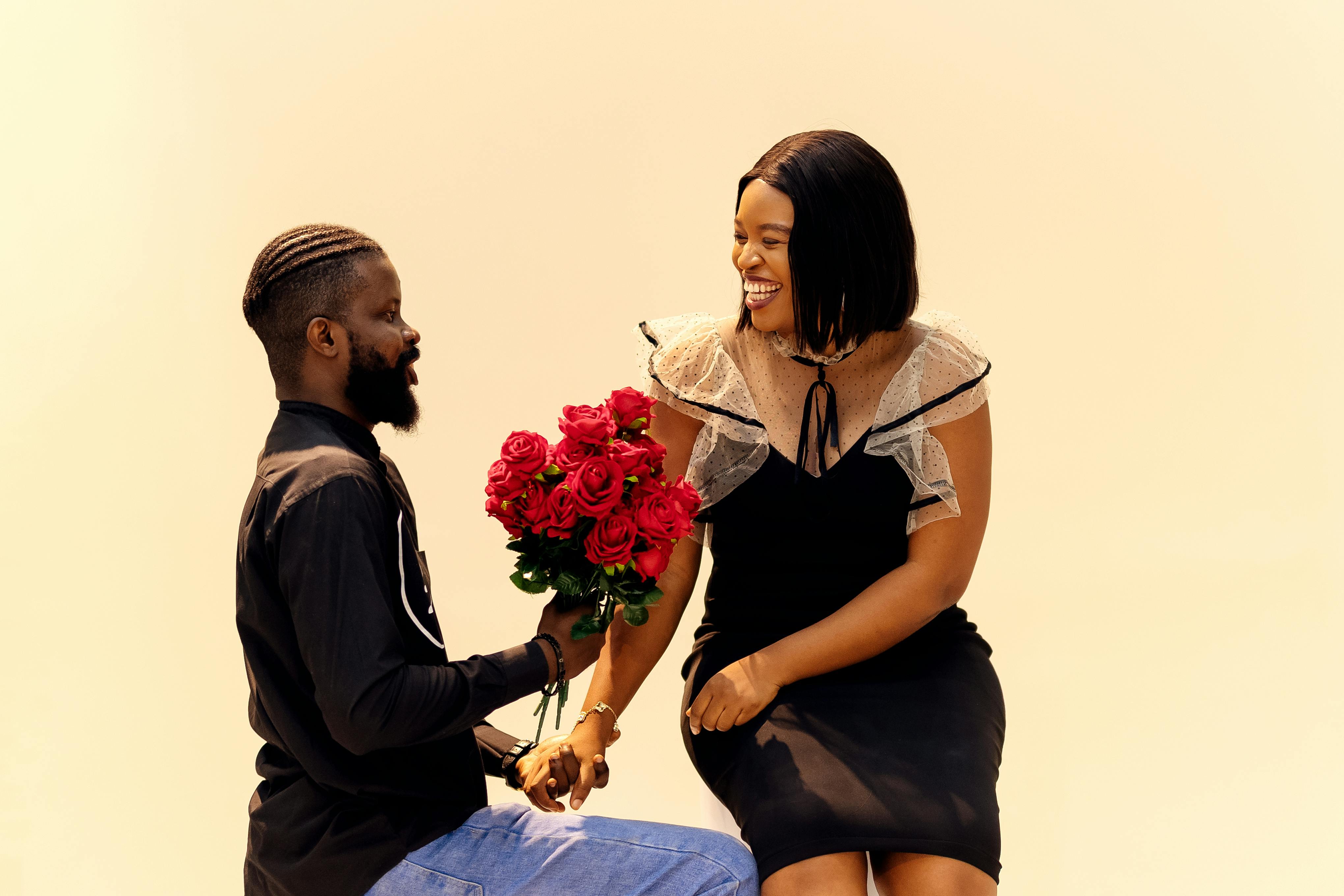 A loving couple sharing a romantic moment with red roses in Lagos, Nigeria.