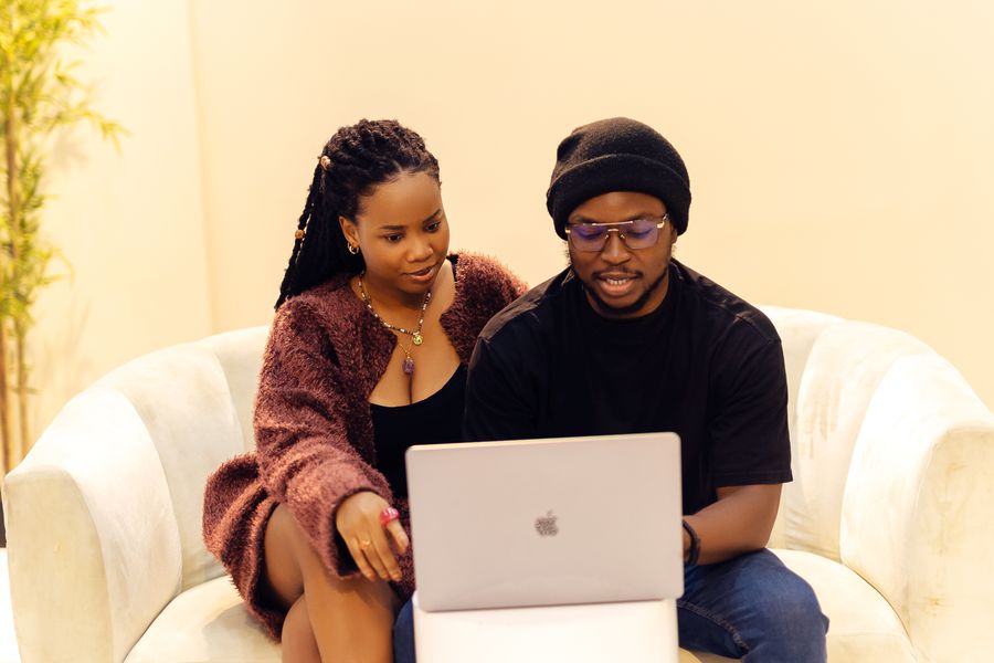 Two African colleagues sitting together and working on a laptop