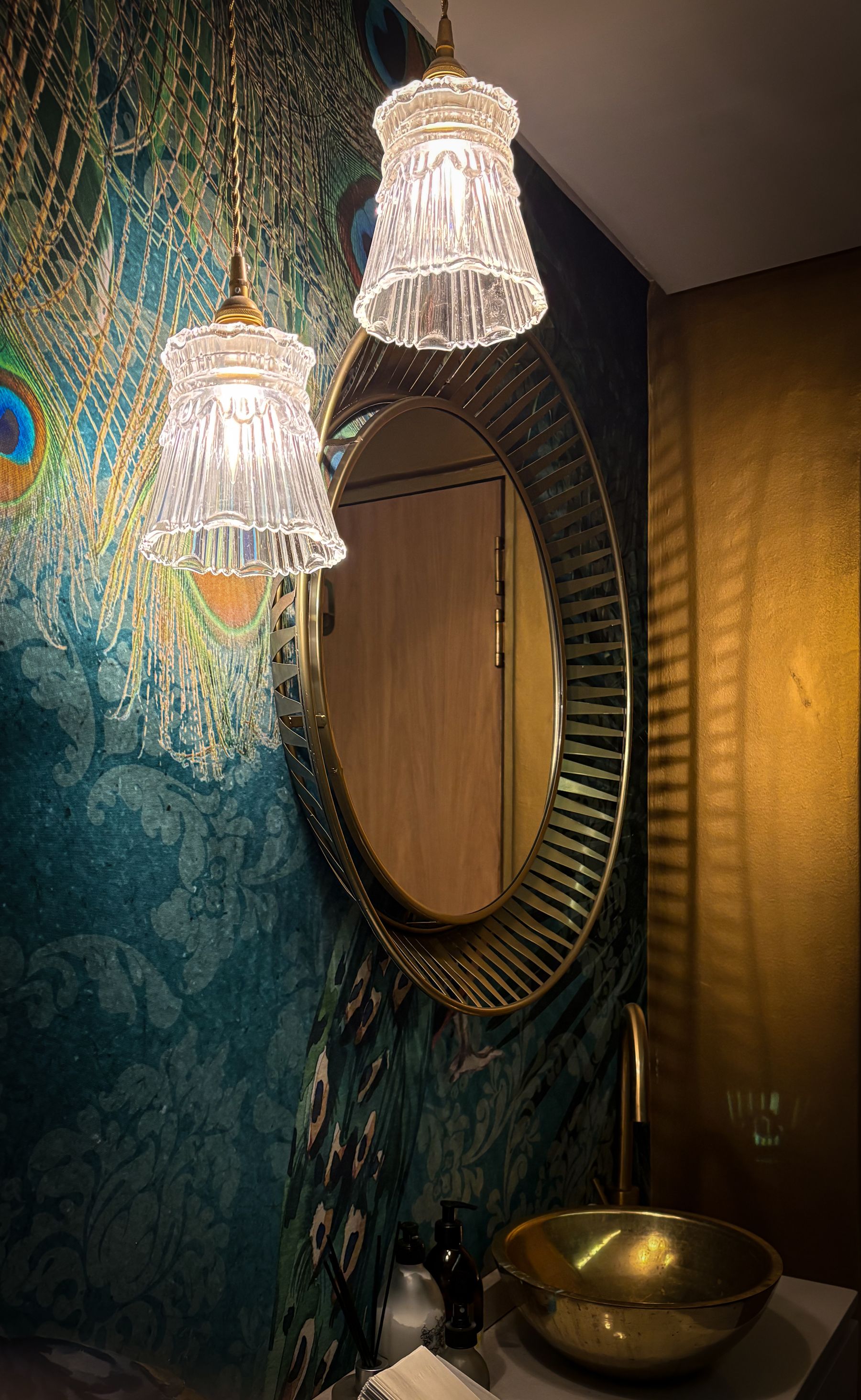 Bathroom vanity with ornate mirror, gold faucet and warm decorative lighting