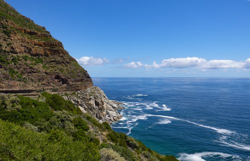 Free Breathtaking view of a rugged coastal cliff meeting the expansive blue ocean. Stock Photo
