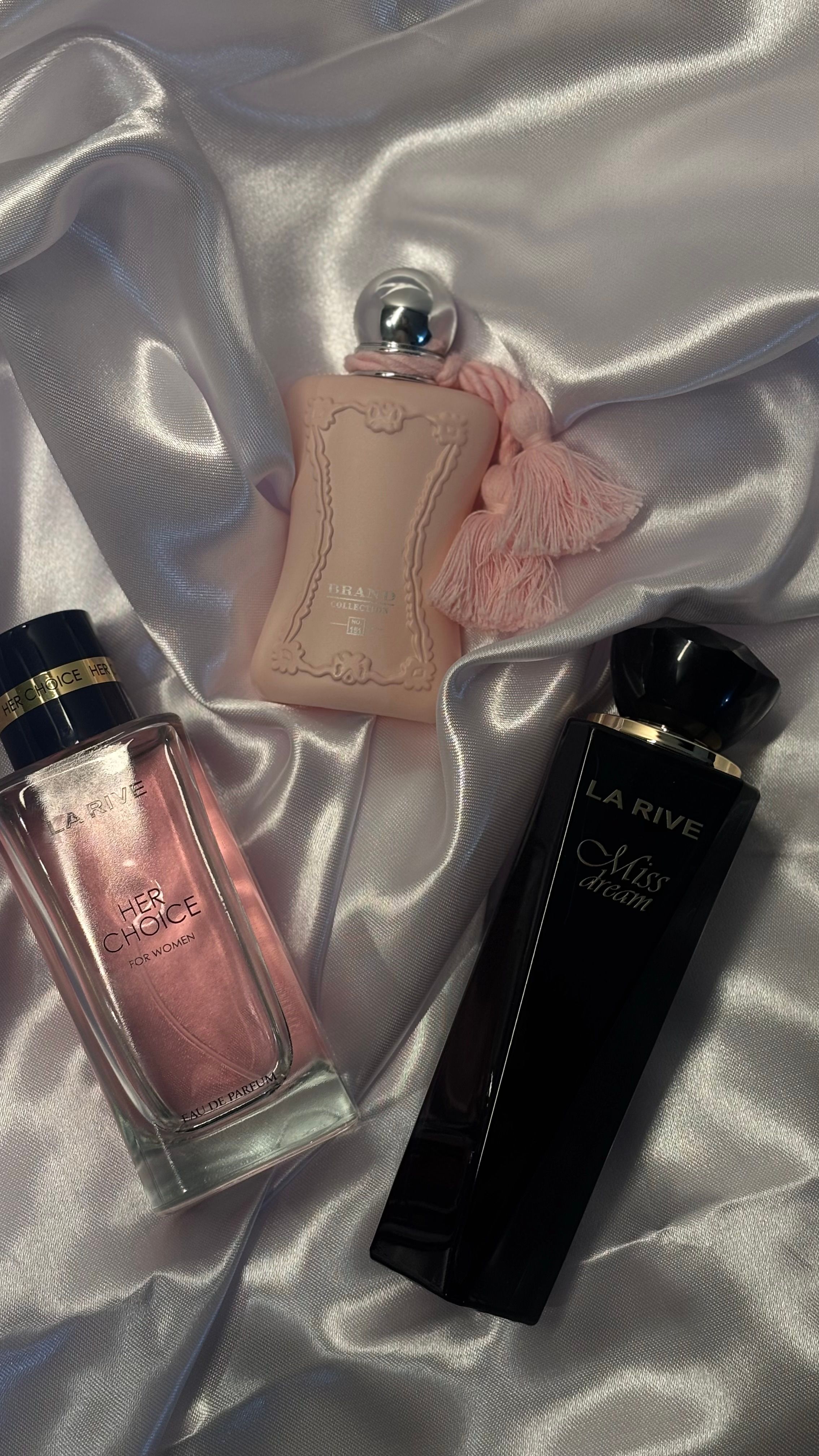Elegant arrangement of perfume bottles on satin fabric. Ideal for beauty and luxury themes.