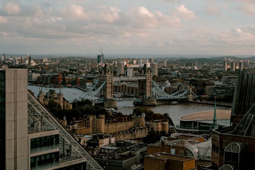 Aerial cityscape of London featuring Tower Bridge and urban skyline during daytime.