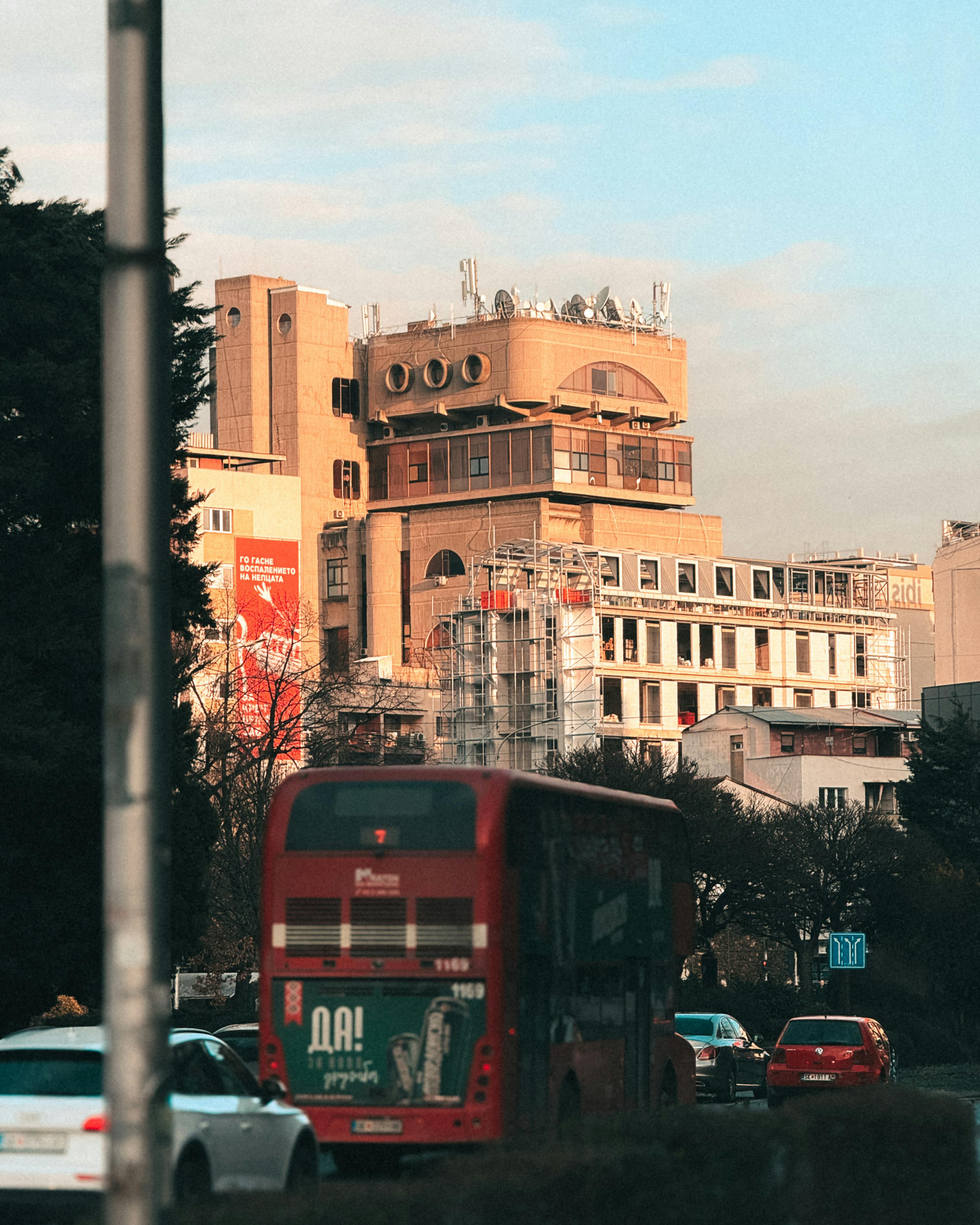 Free Red double-decker bus in a city center near modern buildings. Stock Photo