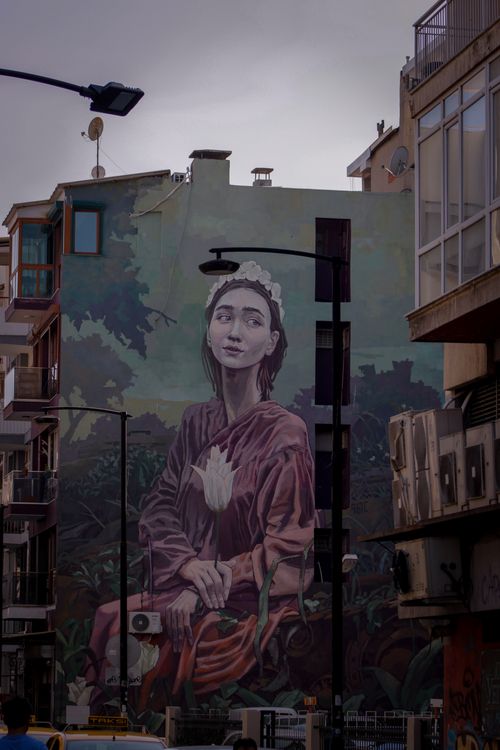 Free Large mural depicting a thoughtful woman on a city building in an urban area. Stock Photo