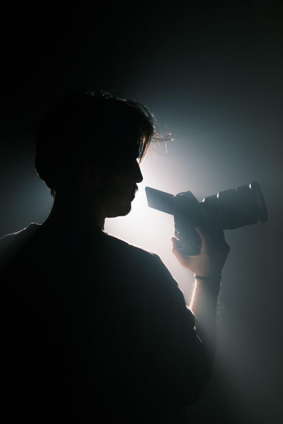 Silhouette of a videographer holding a professional camera