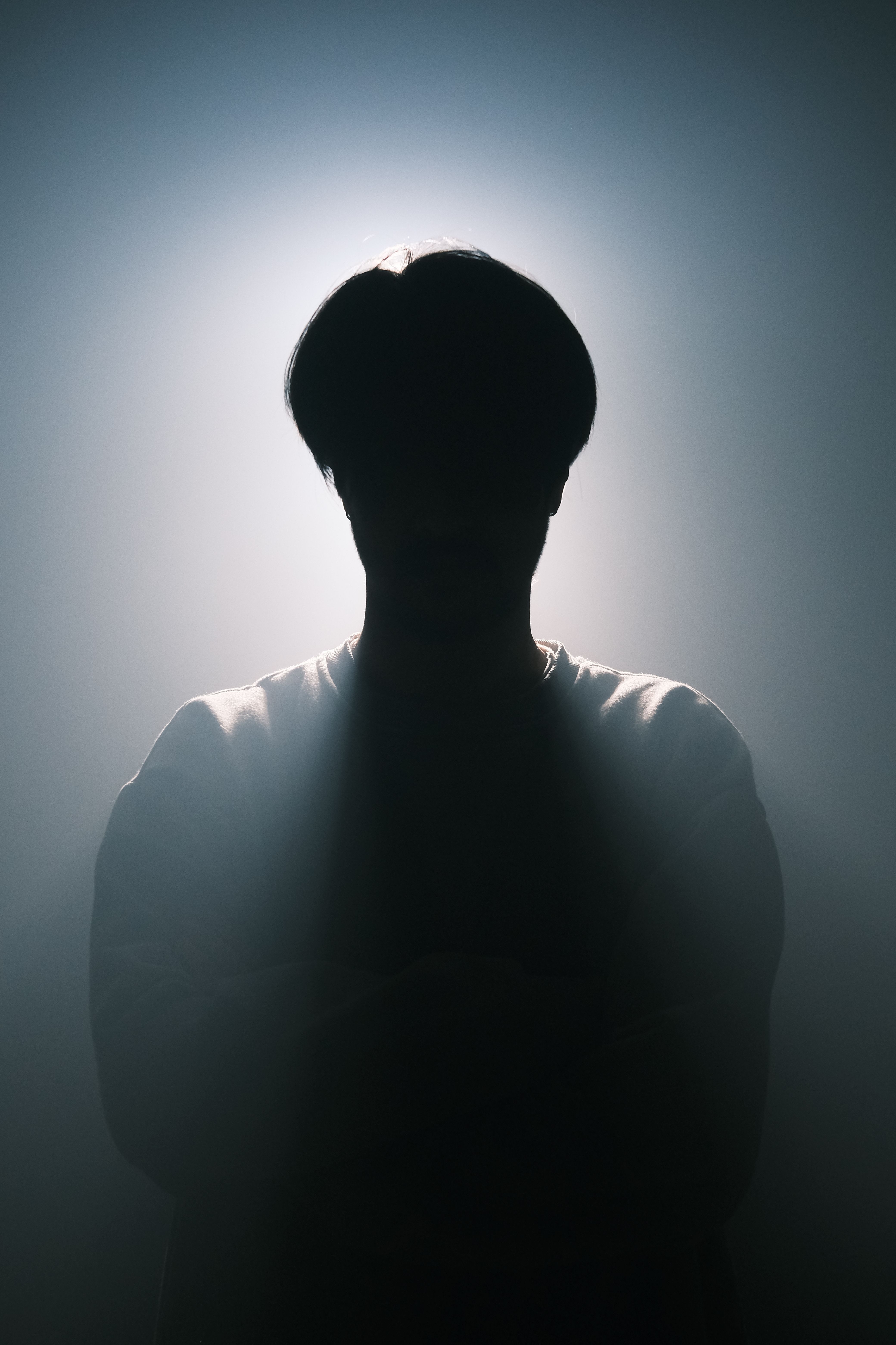 Silhouette of a person with dramatic backlighting creating a mysterious and moody atmosphere.