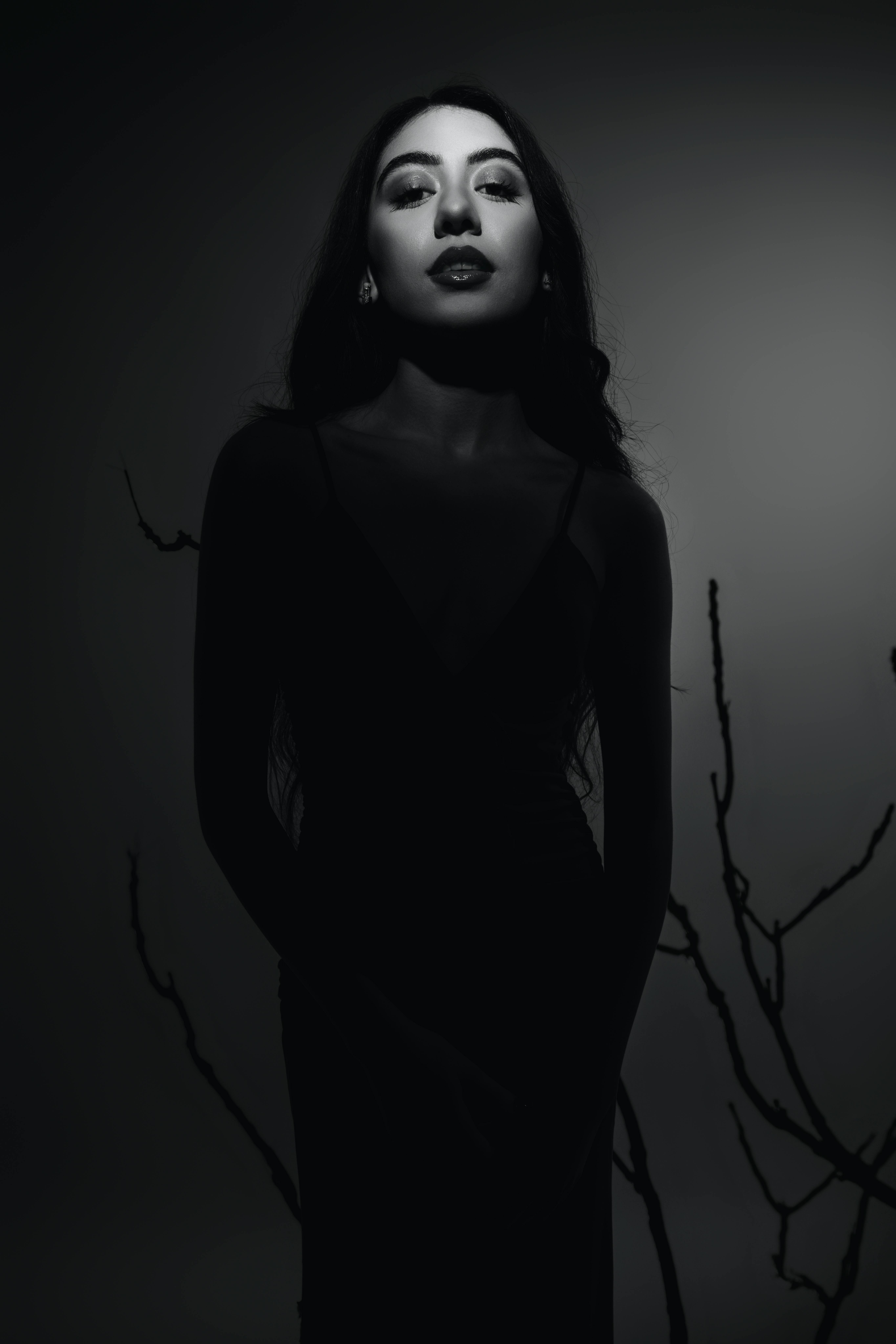 Dramatic black and white portrait highlighting elegance and mystery in a studio setting.