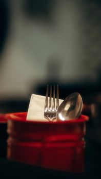 Close-up of a fork and spoon in a red holder, ideal for dining visuals.