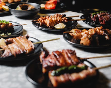 A variety of delicious Japanese yakitori skewers presented on black plates, perfect for food enthusiasts.