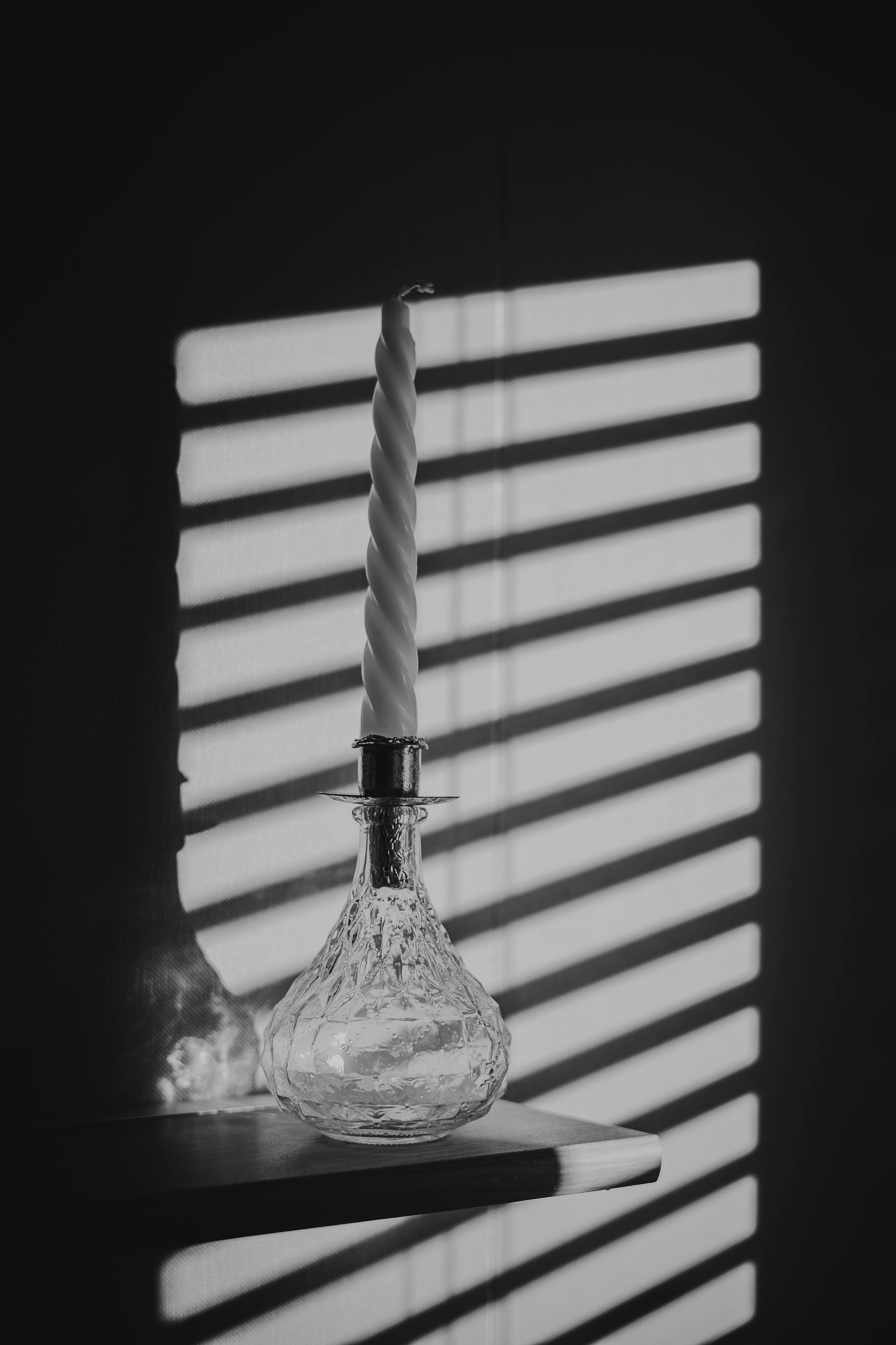 無料 壁に影を落とすテクスチャガラスのキャンドルホルダーの白黒画像。 写真素材