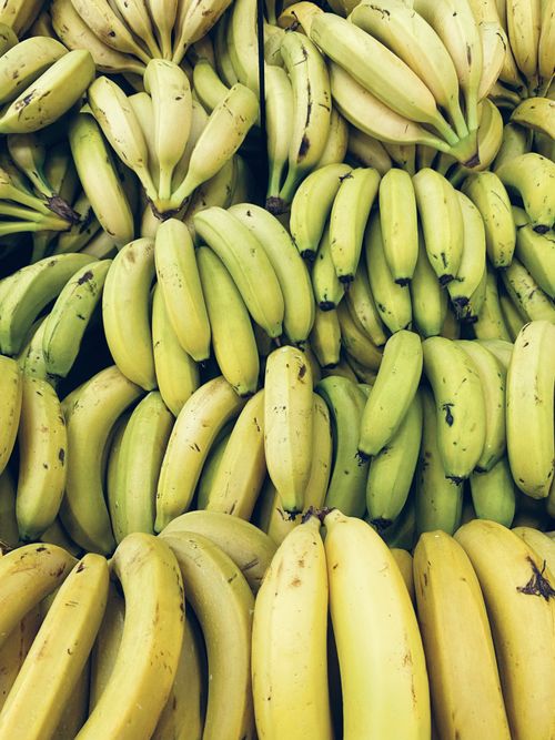 Free A vibrant pile of ripe bananas at a market in Brasil, showcasing tropical freshness. Stock Photo