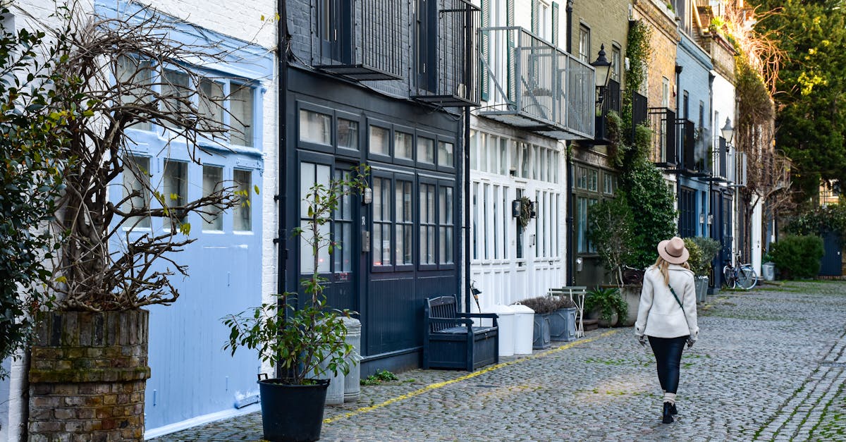 Woman walking down a picturesque cobblestone mews street in London, England.