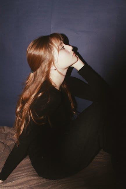 Artistic portrait of a young woman in profile with thoughtful pose.