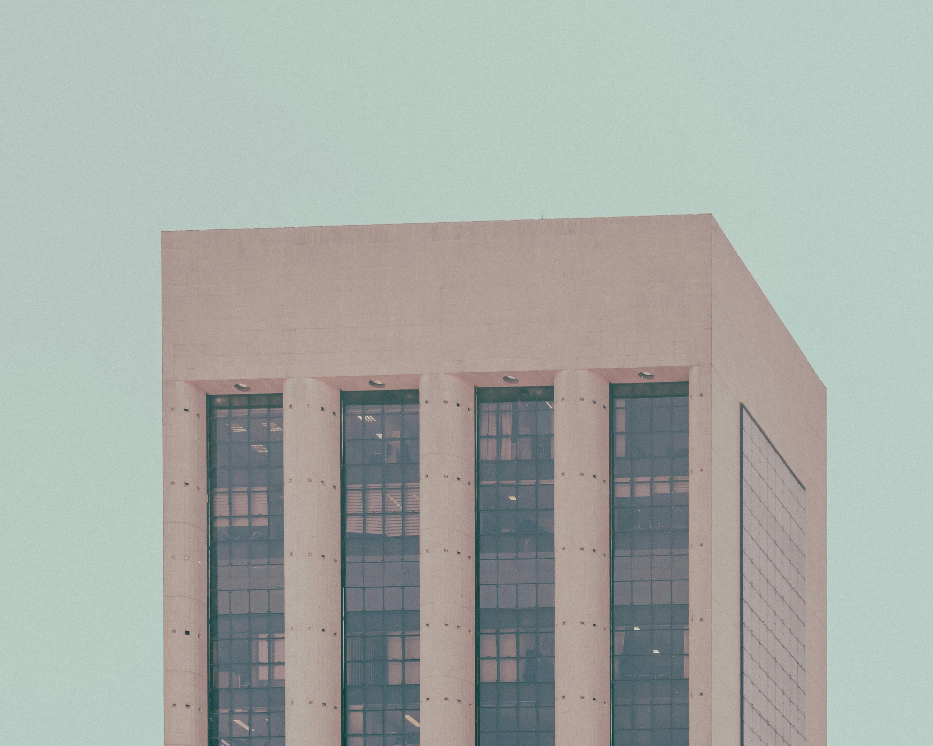 bezplatná Abstraktní pohled na moderní budovu s vysokými sloupy proti jasné obloze, zdůrazňující minimalismus. Základová fotografie