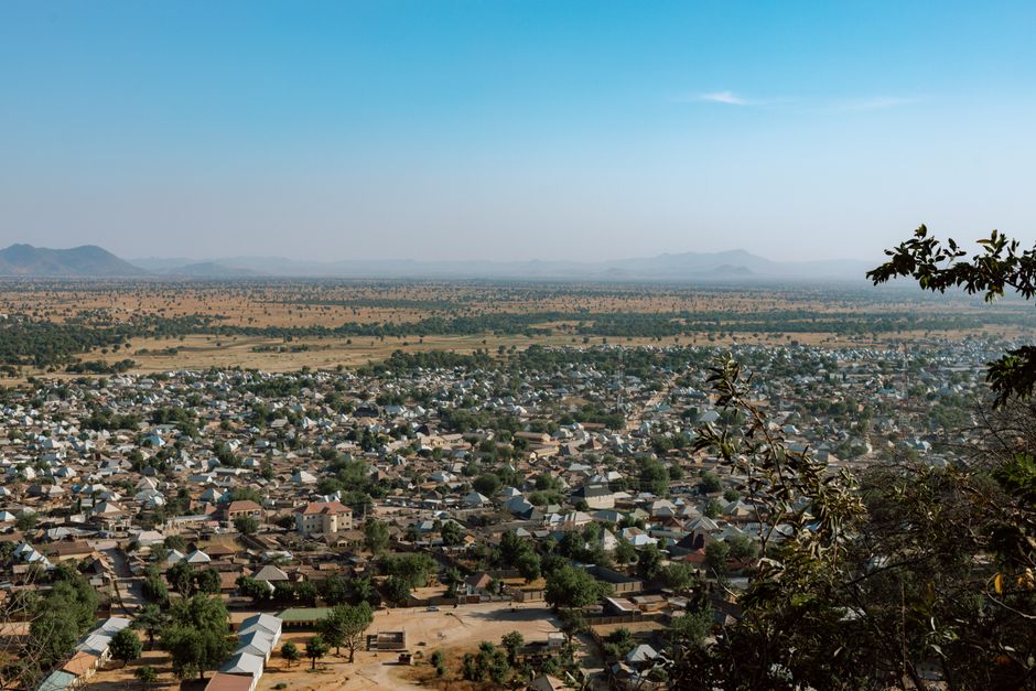 Aerial view of a small town sprawling across a vast, arid landscape under a clear sky.