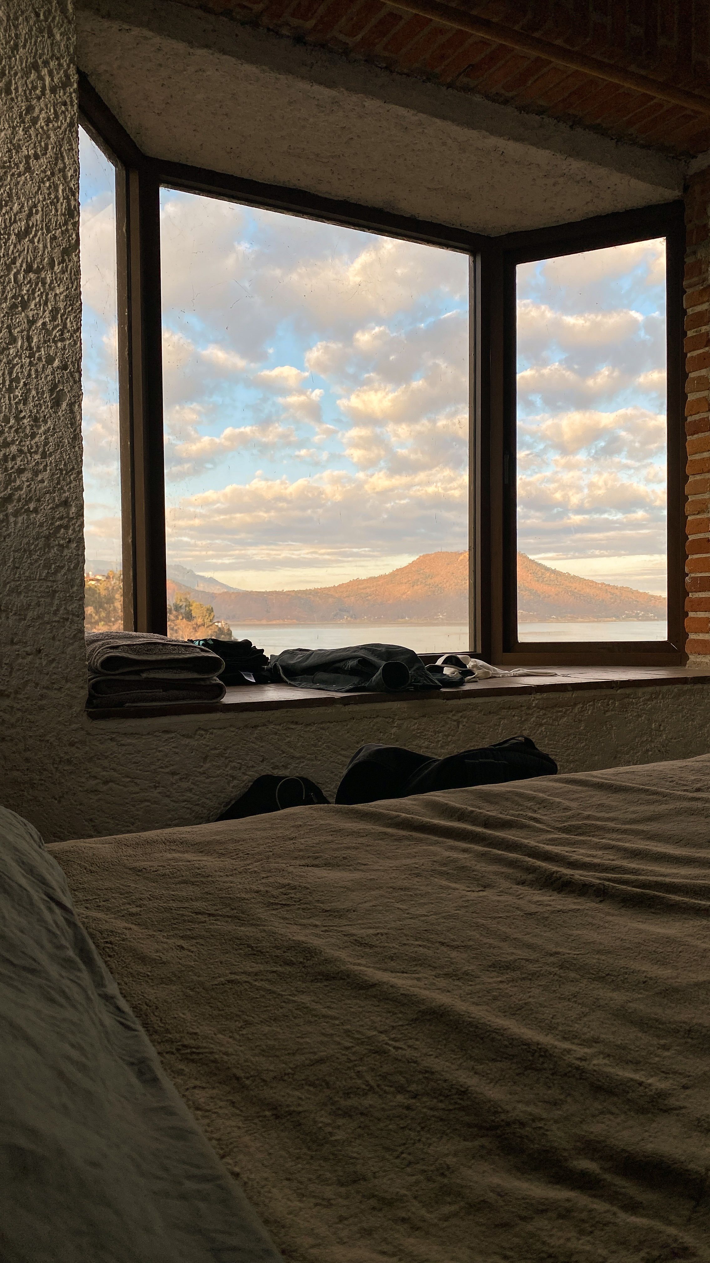 Fotomural Vista serena del lago y el cielo de Valle de Bravo desde una acogedora ventana del dormitorio.