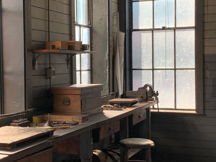 Atelier historique éclairé par une fenêtre avec établi en bois