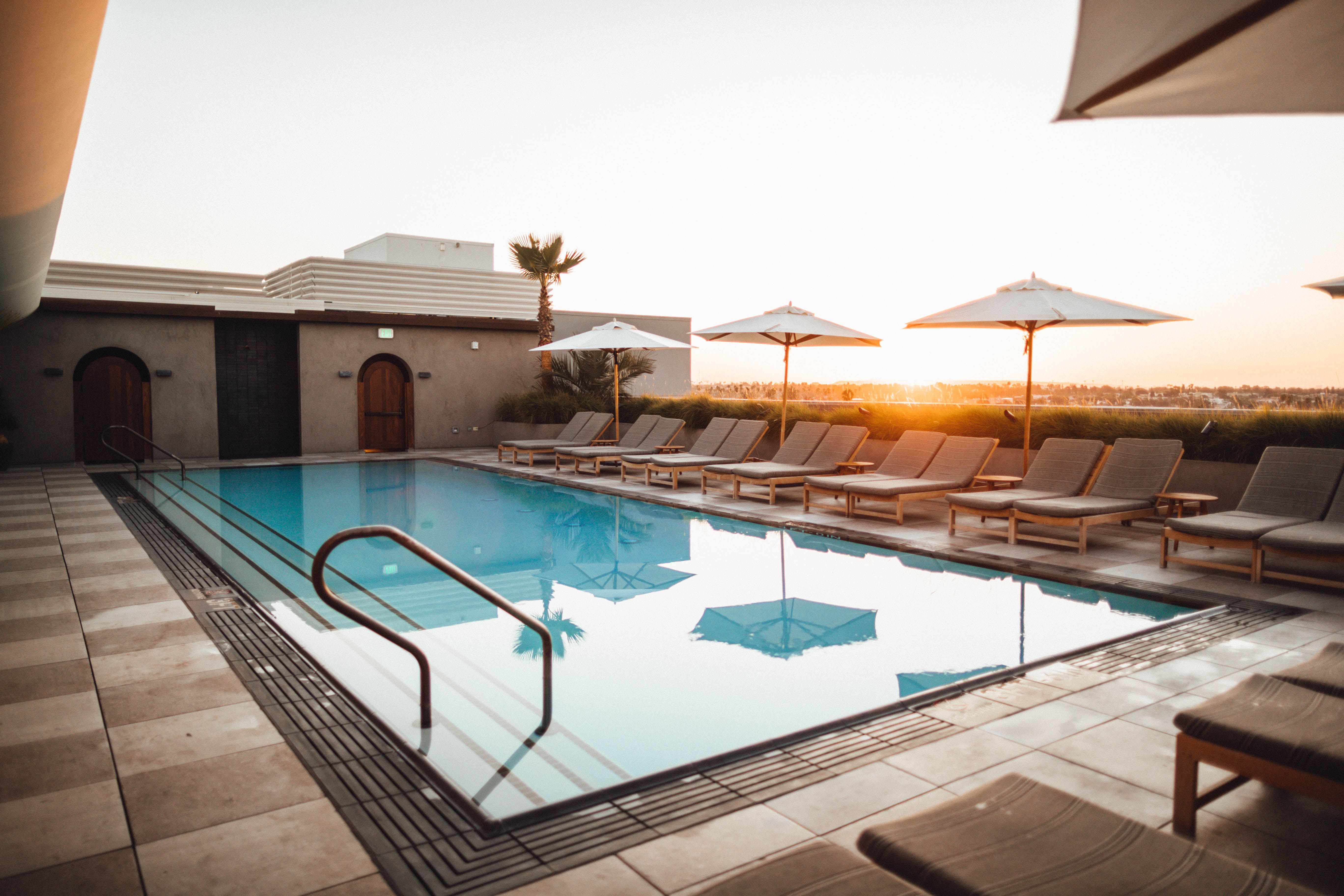 Lounge Chairs With Umbrella Near Swimming Pool · Free Stock Photo