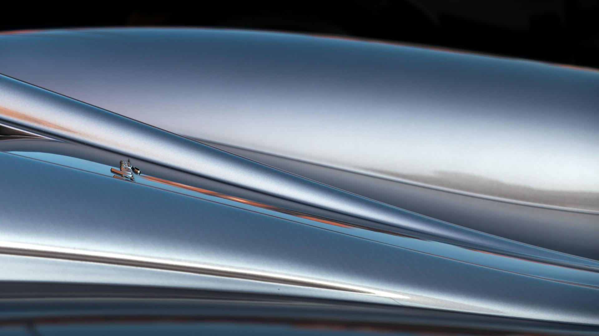 A detailed close-up of a sleek silver supercar's smooth curves and metallic finish.